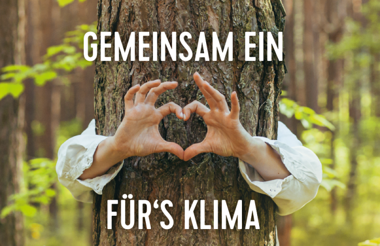 Eine Frau im Wald umarmt einen Baum und formt mit den Händen ein Herz.